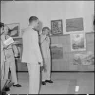 Des officiers visitent une exposition de peinture à la base aérienne 210 (BA 210).
