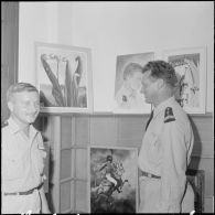 Des officiers visitent une exposition de peinture à la base aérienne 210 (BA 210).