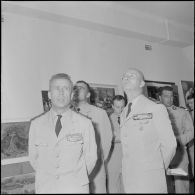 Des officiers visitent une exposition de peinture à la base aérienne 210 (BA 210).