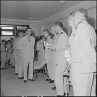 Des officiers visitent une exposition de peinture à la base aérienne 210 (BA 210).