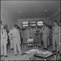 Des officiers visitent une exposition de peinture à la base aérienne 210 (BA 210).