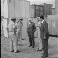 Des directeurs de l'entreprise Danzas et Tailleur s'entretiennent avec des militaires au milieu de containers au port d'Oran.