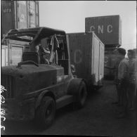 Chargement d'un container de l'entreprise Danzas et Tailleurs, à l'aide d'un Fenwick, au port d'Oran.