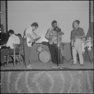 Groupe théâtral de Blida se produisant sur la scène du cinéma de La Reghaïa. Concert de musiciens sur scène.