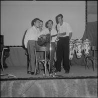 Groupe théâtral de Blida se produisant sur la scène du cinéma de La Reghaïa. Des chanteurs et un musicien.