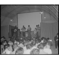 Groupe théâtral de Blida se produisant sur la scène du cinéma de La Reghaïa. Concert de musiciens sur scène.