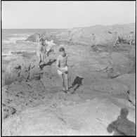 Activités sportives d'une section du 152e régiment d'infanterie (RI). Des soldats courent sur des rochers le long de la côte.