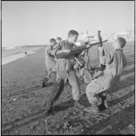 Entraînement d'une section du 152e régiment d'infanterie (RI) avec des fusils MAS 36 sur une plage.
