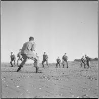 Activités sportives d'une section du 152e régiment d'infanterie (RI). Des soldats s'entraînent à la lutte sur une plage.