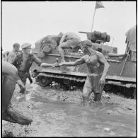 Un légionnaire du 1er régiment étranger de cavalerie sort couvert de boue et d'huile après avoir vidangé un engin amphibie M29 Weasel embourbé, au cours de l'opération Jeanne d'Arc. [description provisoire]