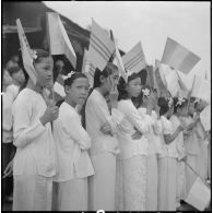 De jeunes écolières accueillent les autorités brandissant le drapeau de l'Etat du Vietnam lors de la cérémonie de réouverture de la route Tan Lap-Go Cong. [description provisoire]