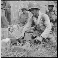 Un caporal du 19e bataillon vietnamien affute son coupe-coupe dans un moment de repos, au cours de l'opération Typhon en plaine des Joncs. [description provisoire]