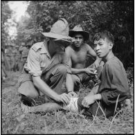 Au cours d'une halte, le médecin-capitaine Michel Bernard soigne un partisan du vietminh fait prisonnier au cours de l'opération Aspic. [description provisoire]