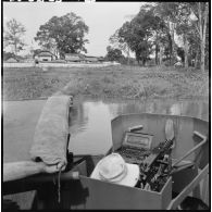 Passage d'une vedette blindée du 4e régiment de dragons patrouillant sur la rivière de Saigon près du poste de Ben Luc.