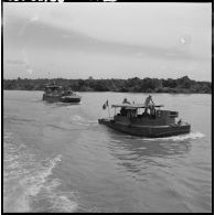 Une vedette du 4e régiment de dragons suivie d'un LCM Monitor escortant le convoi de jonques Michelin sur la rivière de Saigon.