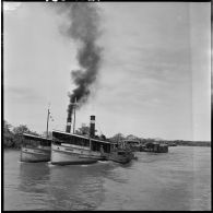 Convoyage de jonques Michelin transportant du caoutchouc sur la rivière de Saigon.