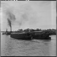 Convoyage de jonques Michelin transportant du caoutchouc sur la rivière de Saigon.