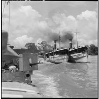 Convoyage de jonques Michelin transportant du caoutchouc sur la rivière de Saigon.