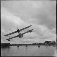 Convoi de vedettes blindées du 4e régiment de dragons survolées par un hydravion sur la rivière de Saigon.