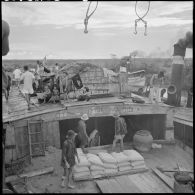 Déchargement à Dau Tieng des chalands de ravitaillement.