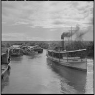Convoyage de jonques Michelin transportant du caoutchouc sur la rivière de Saigon.