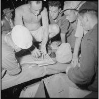 Avant le départ, le lieutenant Malfait donne des instructions à ses chefs de vedettes à la lueur d’une lampe électrique.