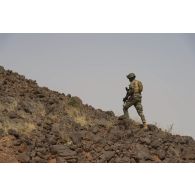 Un soldat nigérien gravit un point haut pour une reconnaissance du Liptako, au Niger.