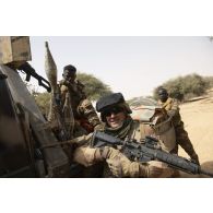 Un soldat pose aux côtés d'un soldat nigérien de la 112e compagnie de sécurité et d'intervention (CSI) monté à bord de son pick-up dans le secteur du Liptako, au Niger.