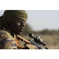 Un tireur de précision nigérien de la 112e compagnie de sécurité et d'intervention (CSI) sécurise le périmètre au moyen de son fusil de précision SVD Dragunov à Tongo Tongo, au Niger.