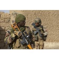 Un tireur de précision nigérien de la 112e compagnie de sécurité et d'intervention (CSI) sécurise le périmètre au moyen de son fusil de précision SVD Dragunov à Tongo Tongo, au Niger.