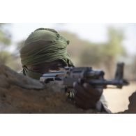 Un soldat nigérien de la 112e compagnie de sécurité et d'intervention (CSI) sécurise le périmètre au moyen de son fusil d'assaut de type AKM à Tongo Tongo, au Niger.