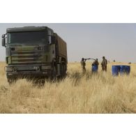 Des éléments du Service de l'énergie opérationnelle (SEO) ravitaillent un camion-citerne Scania en carburant après une livraison par air dans le secteur du Liptako, au Niger.