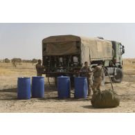 Des éléments du Service de l'énergie opérationnelle (SEO) ravitaillent un camion-citerne Scania en carburant après une livraison par air dans le secteur du Liptako, au Niger.