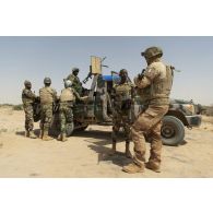 Un agent du centre de mise en oeuvre influence opération (CMO-IO) se coordonne avec un chef de section nigérien de la 3e compagnie de sécurité et d'intervention (CSI) pour la caractérisation du village de Kinabay, au Niger.