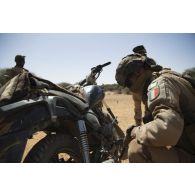 Un soldat de la section d'aide à l'engagement débarqué (SAED) contrôle une moto trouvée dans le secteur du Liptako, au Niger.