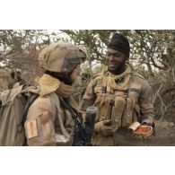 Un soldat de la section d'aide à l'engagement d"barqué (SAED) et un soldat nigérien prennent leur repas dans le secteur du Liptako, au Niger.