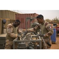 Des opérateurs du Service de l'énergie opérationnelle (SEO) manipulent la motopompe d'un réservoir souple à carburant sur la base de Gossi, au Mali.