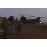 Des soldats attendent d'embarquer à bord d'un hélicoptère britannique Chinook CH-47 de la Royal Air Force à Gao, au Mali.