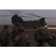 Des soldats attendent d'embarquer à bord d'un hélicoptère britannique Chinook CH-47 de la Royal Air Force à Gao, au Mali.