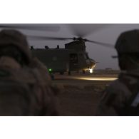 Des soldats attendent d'embarquer à bord d'un hélicoptère britannique Chinook CH-47 de la Royal Air Force à Gao, au Mali.