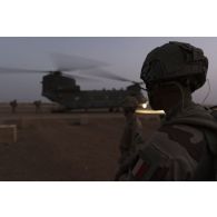 Des soldats attendent d'embarquer à bord d'un hélicoptère britannique Chinook CH-47 de la Royal Air Force à Gao, au Mali.