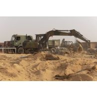 Une pelle hydraulique modèle 317 nivelle le sol de la base de Gossi, au Mali.
