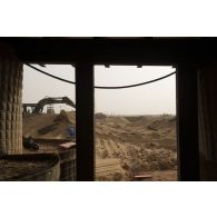 Une pelle hydraulique modèle 317 nivelle le sol de la base de Gossi, au Mali.