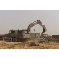 Une pelle hydraulique modèle 317 nivelle le sol de la base de Gossi, au Mali.