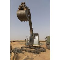 Une pelle hydraulique modèle 317 nivelle le sol de la base de Gossi, au Mali.
