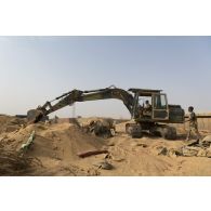Une pelle hydraulique modèle 317 nivelle le sol de la base de Gossi, au Mali.