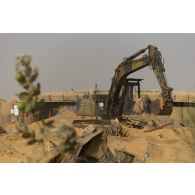 Une pelle hydraulique modèle 317 nivelle le sol de la base de Gossi, au Mali.