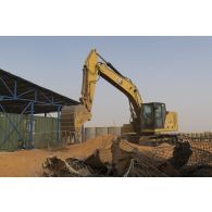 Une pelle hydraulique modèle 320 nivelle le sol de la base de Gossi, au Mali.