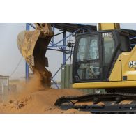 Une pelle hydraulique modèle 320 nivelle le sol de la base de Gossi, au Mali.