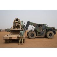 Un chariot élévateur lourd (CEL) charge une bétonnière sur un camion semi-remorque à Gao, au Mali.